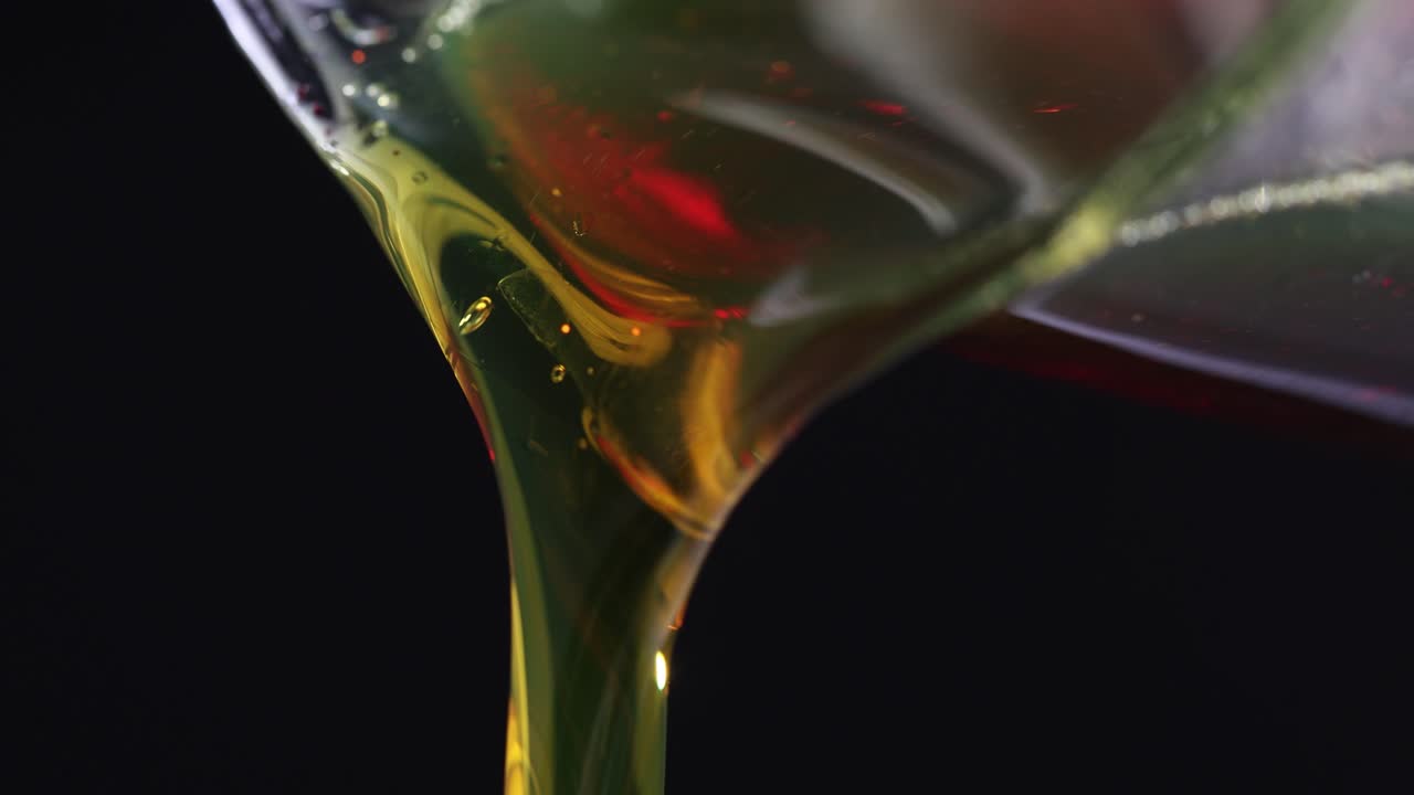 Close-up of golden viscous liquid being poured