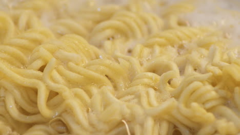 macro shot of a ramen noodles on a bubbling and boiling water