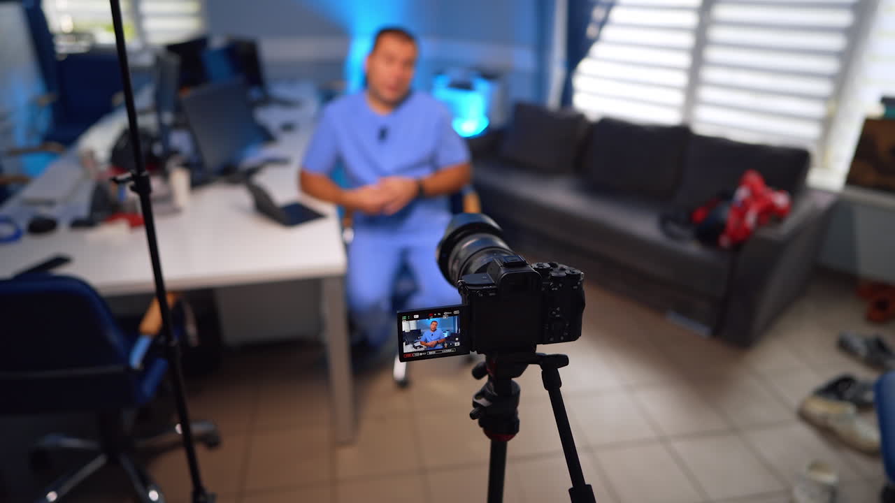 Doctor in his office records a video for the blog on the professional camera. Medical vlogging concept. Selective focus