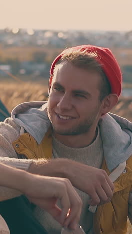 lovely young gay couple spends time together in tourist camp on meadow in early autumn morning slow motion closeup