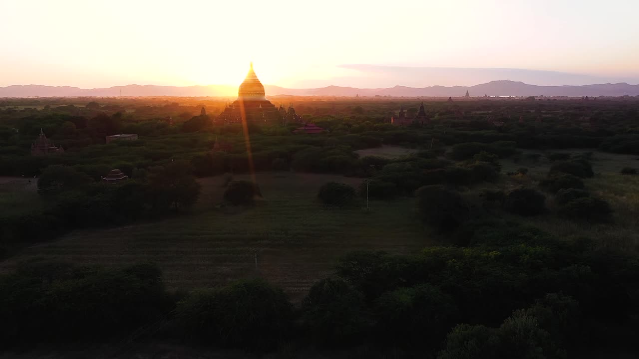 Avvicinamento aereo sulla Pagoda Dhammayazika retroilluminata all'alba con lens flare