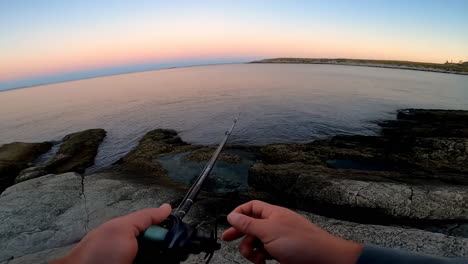 fishing at a rocky coast during sunset or sunrise