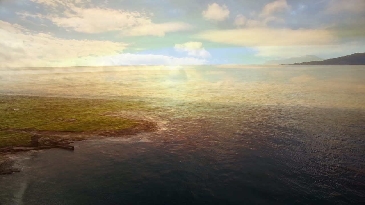 Reflecting colorful sky, calm ocean waves near distant coastline creating animation