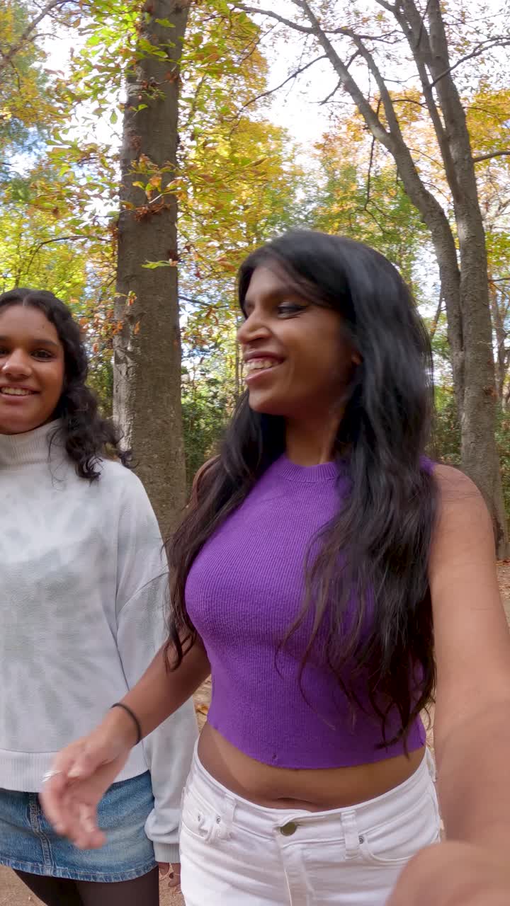 Dos mujeres abrazándose en un parque en otoño