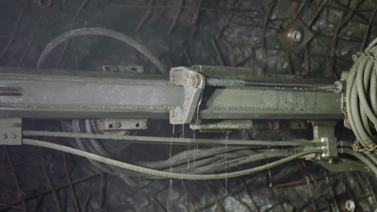 파이프와 냉각액을 가진 로 ⁇  드릴이 광산에서 작동합니다.