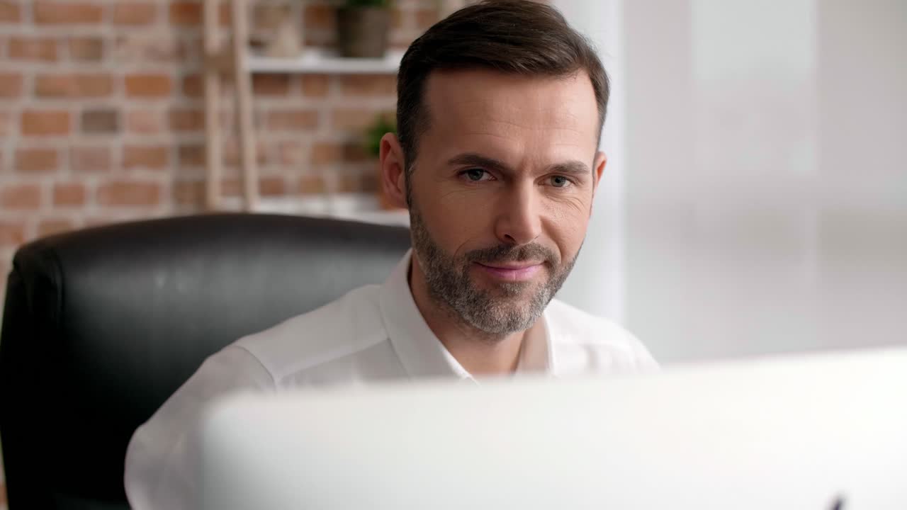 hombre enfocado usando una computadora portátil en su oficina