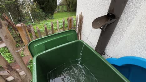 wide shot of water flowing out of a typical german drain pipe during rain