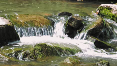 Ein-Beruhigender-Anblick-Von-Kristallklarem-Wasser,-Das-über-Steine-Fließt-Und-Zu-Hellem-Schaum-Sprudelt