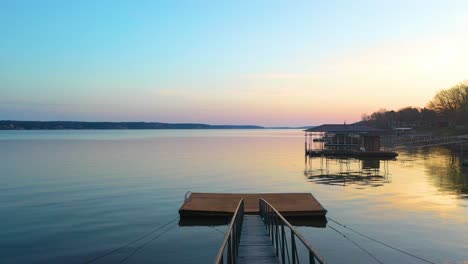 puente con pasamanos moviéndose hacia la plataforma de natación en la orilla del lago durante la puesta de sol en el gran lago o' the cherokees, oklahoma