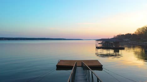 bridge with handrail moving towards swimming platform at the lakeshore during sunset in grand lake o' the cherokees, oklahoma