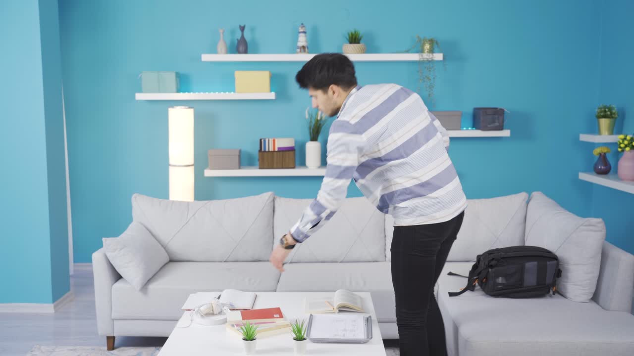 학교에서 피곤하고 잠을 못 자는 젊은이가 소파에 누워 있습니다.