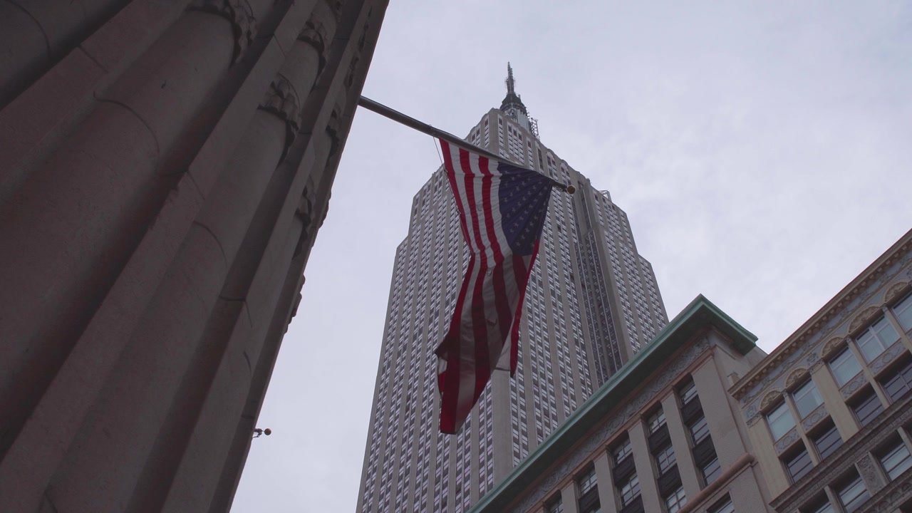 NYC: Empire State Building con una bandiera americana in primo piano - Midtown Manhattan - New York City, USA.