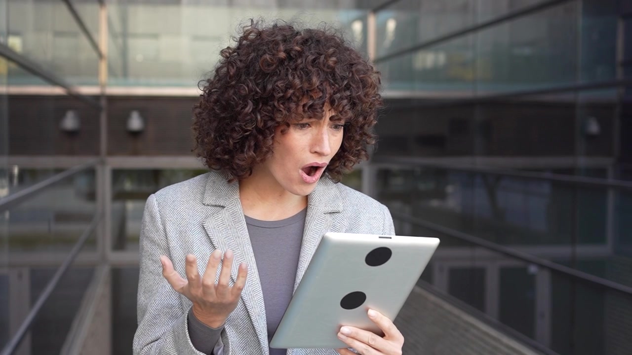 Una donna professionista impegnata con il suo tablet in un ambiente di lavoro moderno ed elegante.
