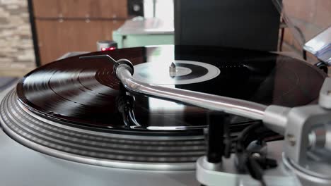 close up of a vinyl being played on a silver turntable