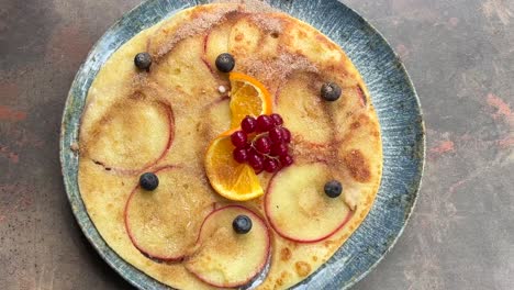 apple pancake with berries and orange slices