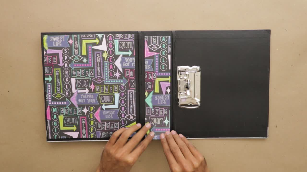 Putting papers with cool design on ring binder to make scrapbook