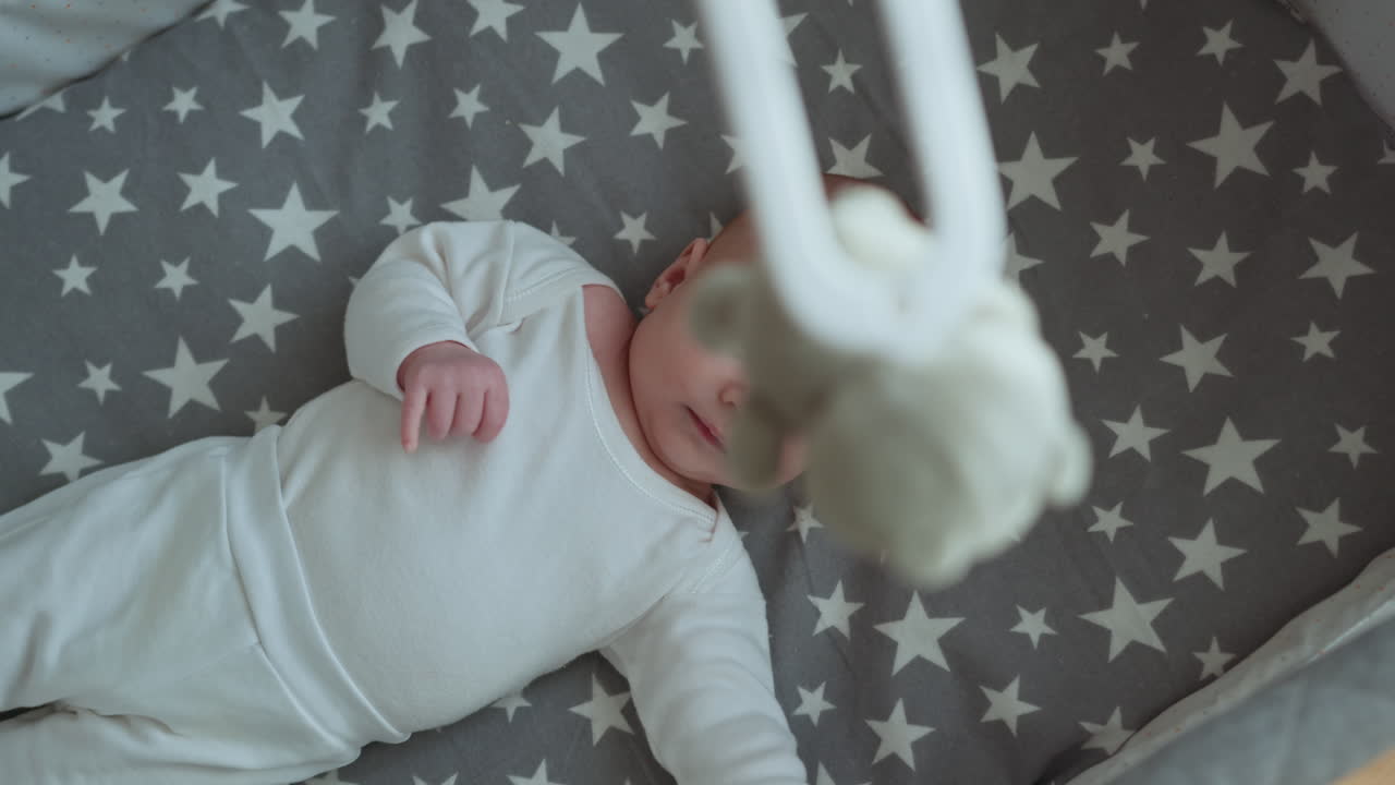 Neonato che dorme profondamente nella culla, avvolto in una morbida coperta, che trasmette tranquillità, innocenza e