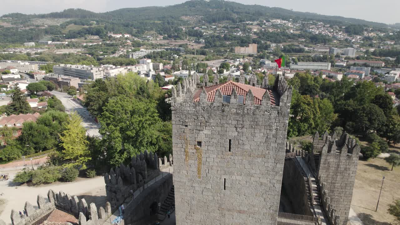 Bandiera portoghese che sventola sulla torre del castello medievale di Guimarães