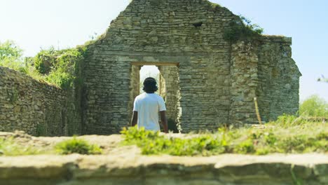 4K-footage-of-black-man-walking-out-of-the-Ruins-of-St-Peter's-Church-on-a-sunny-day