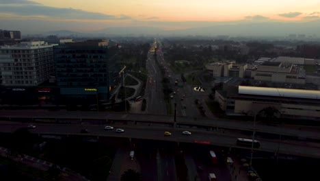 sunrise at 68 avenue in bogota colombia. tilt up over 68 avenue. fluid traffic in the background.