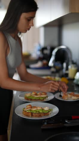 mujer preparando tostadas de aguacate con camarones