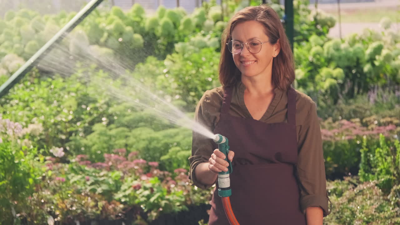 mujer regando plantas en el invernadero