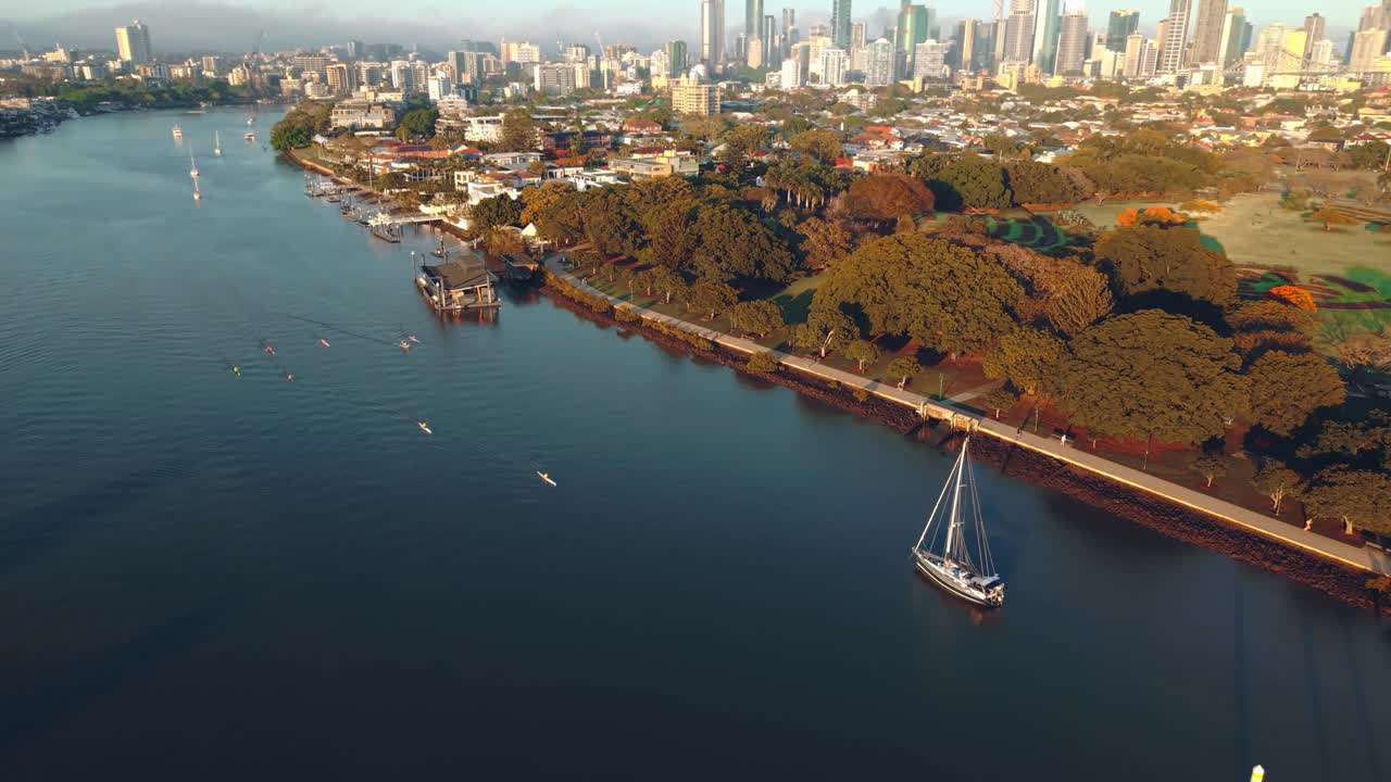 Orbita aerea angolata lungo le barche ancorate nel fiume Brisbane vicino a Teneriffe con banchine e costa visibili, Queensland QLD Australia