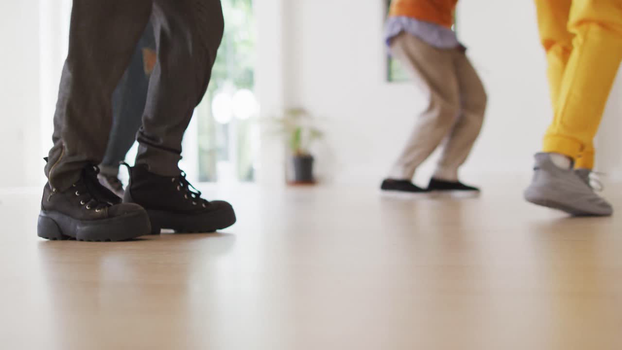 sección baja de diversos bailarines masculinos y femeninos bailando en un estudio de baile, cámara lenta
