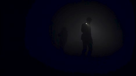 people walking in fog at night with torches