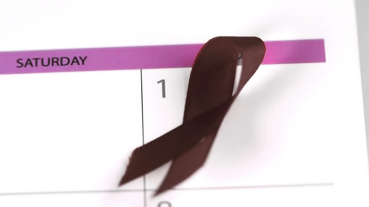 Símbolo da fita vermelha da AIDS caindo sobre um calendário