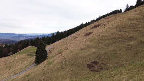 Aerial-view-of-drone-fly-passed-summit-cross-in-mountain-landscape-on-cloudy-day-in-Austria