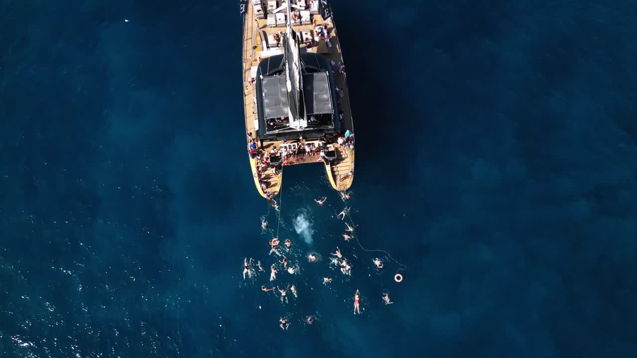 배에서 물로 뛰어내리는 남자, 파란 바다 물에서 카타마란, 섬의 아름다운 만, 테네리프, 배, 여름, 드론