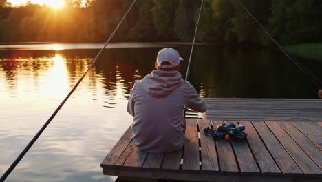 man fishing at sunset on a lakeside pier