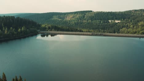 Fresh-water-reservoir-behind-The-Fláje-hydroelectric-dam-between-green-forests,-summer,-Czech-republic