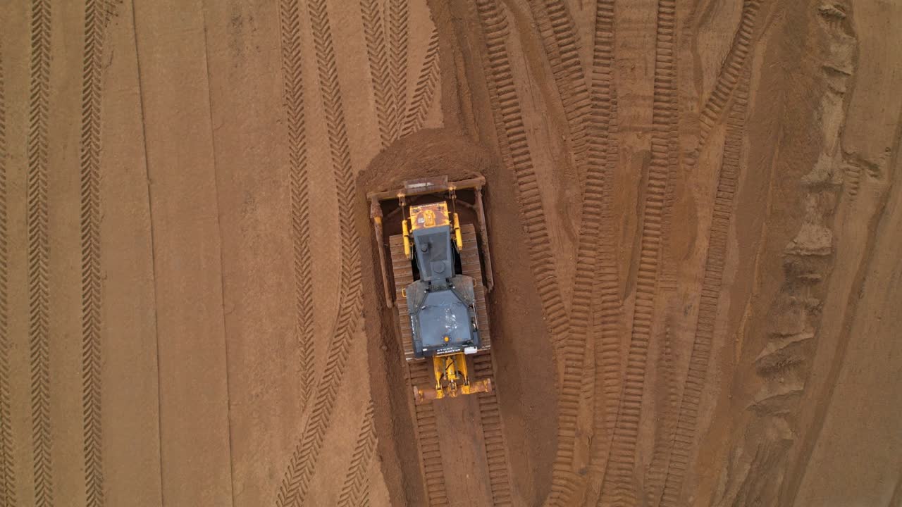Aerial view of a bulldozer leveling the ground on a construction site