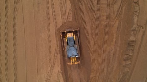 aerial view of a bulldozer leveling the ground on a construction site