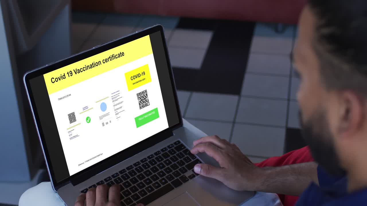 hombre trabajando en el escritorio, certificado de vacunación contra la covid con código qr en la pantalla del portátil