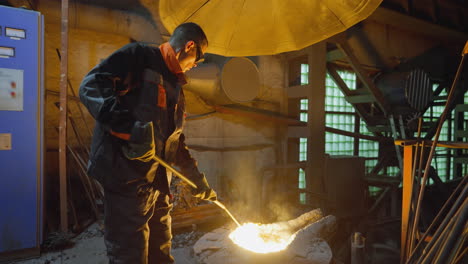 foundry worker controlling molten metal flow from furnace in industrial environment