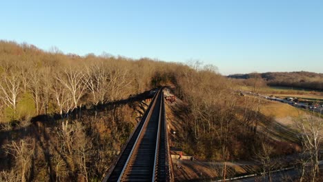 aerial shot pushing forward along the pope lick railroad trestle in louisville kentucky during the sunset