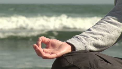 woman meditating on beach