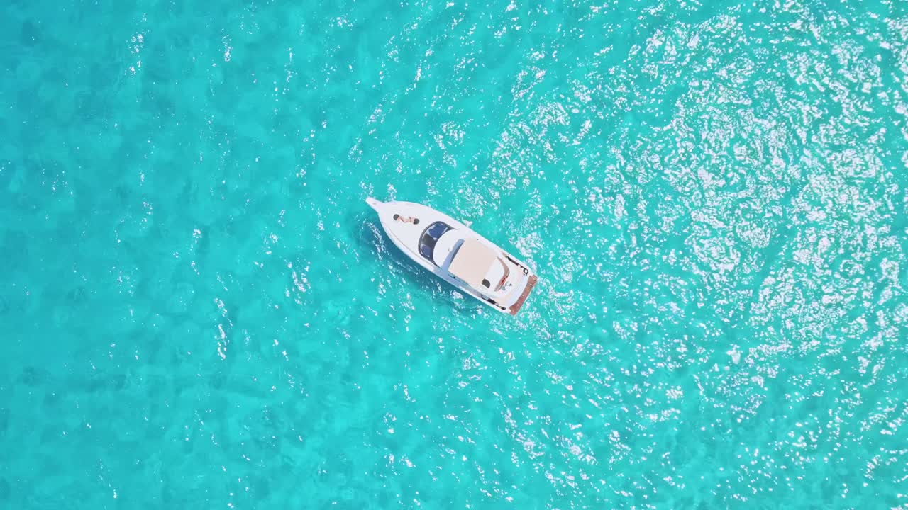 A woman lounges on the bow of a boat in the Mediterranean, soaking up the sun and enjoying the tranquil sea and serene surroundings.