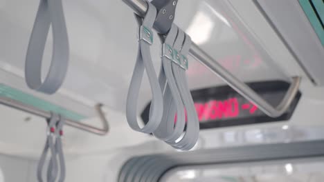 empty train interior with hand straps