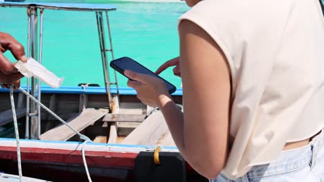 dos personas interactuando con un teléfono inteligente en un barco