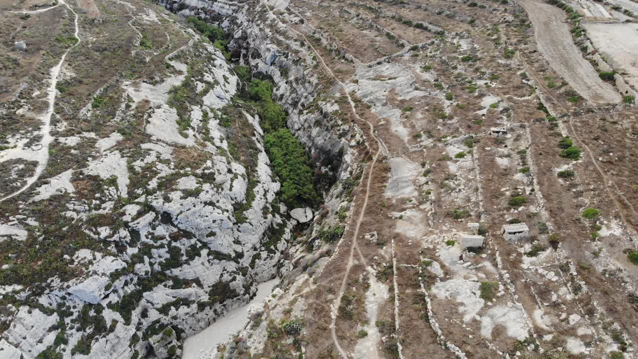 malta, la isla de gozo se secó el cañón del desfiladero y la tierra agrícola vista de la montaña y el pueblo de ghasri