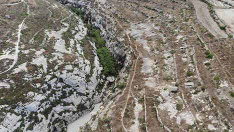 malta, gozo island dried out gorge canyon and agricultural land view of mountain and ghasri village