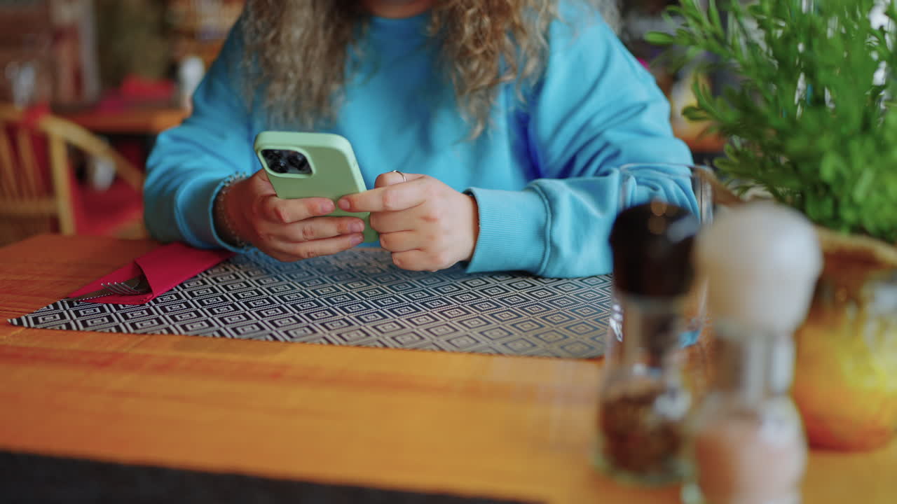 mujer usando el teléfono en un restaurante