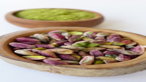 pistachios and pistachio powder in wooden bowls