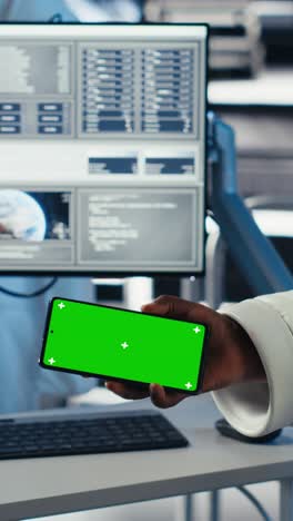 vertical video astronaut reviewing onboard analytics on laptop before stepping out of station
