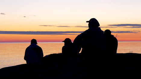 grupo de amigos disfrutando de la vista del horizonte de la puesta de sol y el paisaje marino