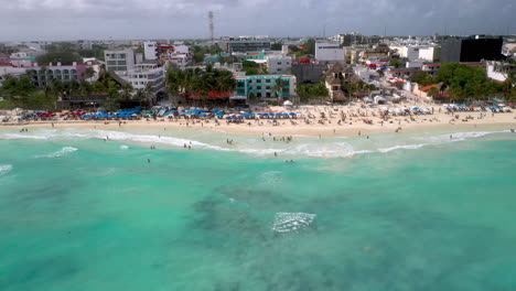 Aufschlussreiche-Drohnenaufnahme-Von-Menschen-Am-Strand-Und-Den-Strandresorts-Von-Playa-Del-Carmen,-Mexiko